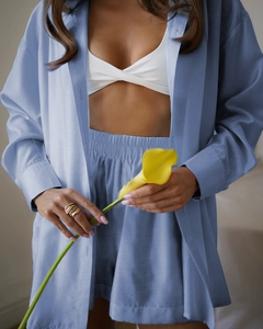 Detail of blue-purple loungewear set featuring silky long-sleeve shirt and matching shorts
