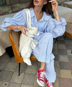Detail of blue and white gingham loungewear set featuring ruffle trim and lantern sleeves