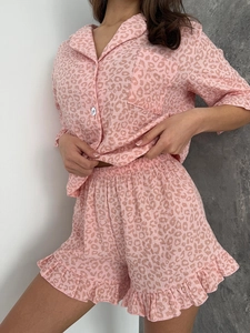 Détail d'un pyjama imprimé léopard rose avec chemise boutonnée et short à volants