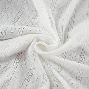 Detailed macro shot of white hollow knit fabric with diamond patterns and vertical textures