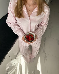 Détail du pyjama à rayures roses avec motifs de cœurs rouges et manches longues