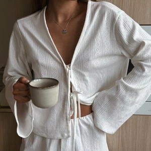 Women white pointelle knit loungewear set featuring long sleeve tie-top and matching shorts