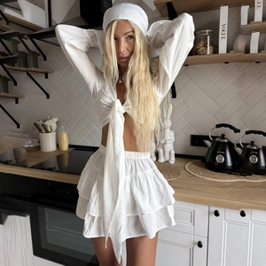 Three-piece white summer resort set with V-neck tie-front top and ruffle skirt