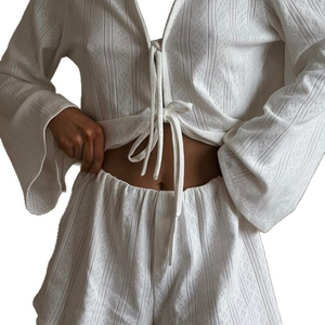 White knit loungewear set featuring tie-front long sleeve top and matching high waist shorts