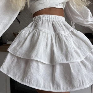 White ruffled mini skirt with tiered layers and elastic high waist for summer wear