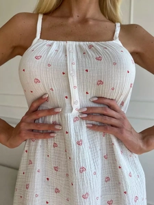 Détail de caraco blanc en coton avec imprimés coeurs rouges et boutons décoratifs