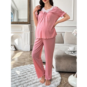 Close-up of pink maternity loungewear featuring delicate white floral lace and bow detail
