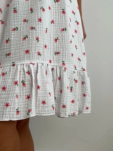 Détail de la nuisette en mousseline blanche avec ourlet à volants et imprimé floral