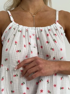 Détail de robe de nuit en coton blanc à imprimé floral rose et boutons décoratifs