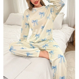 Détail du pyjama crème avec imprimés nœuds bleus et poignets élastiques confortables