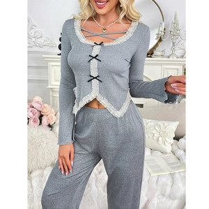 Close-up of grey lounge set with white lace trim, black bow, and irregular hem detail