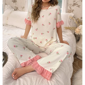 Detail of tulip print pajama set featuring lace ruffled cuffs and soft textured fabric