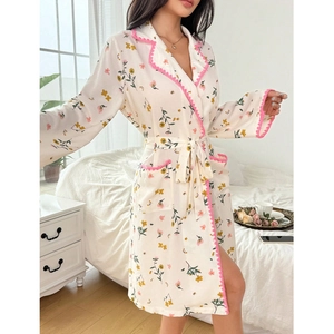 Elegant floral robe with pink scalloped trim and tie-waist in cozy bedroom setting