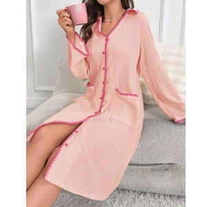 Dettaglio della camicia da notte rosa a maniche lunghe con bordi a onde e texture