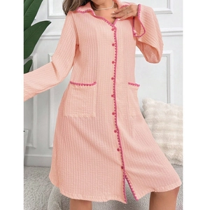 Dettaglio della camicia da notte rosa con bottoni, righe verticali e bordi a balze ondulate