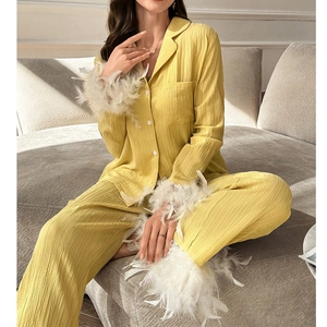 Detail des gelben Pyjama-Sets mit Federbesatz an den Ärmeln und strukturiertem Stoff