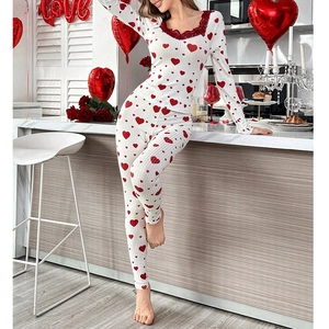Détail du pyjama à motif cœur avec dentelle rouge sur un tissu blanc à côtes