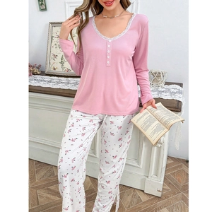 Detailed view of pink lounge top with white lace neckline and floral print pajama pants