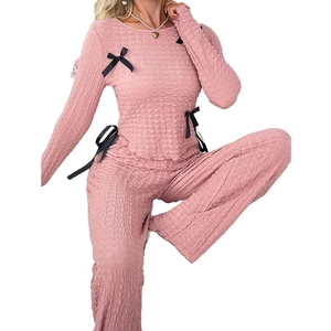 Pink textured two-piece pajama set with long sleeves and black bow details for women