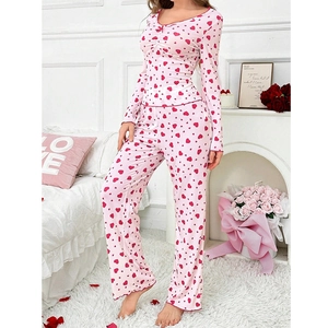 Detail eines rosa Pyjama-Sets mit Herzprint, V-Ausschnitt, Schleife und langen Ärmeln