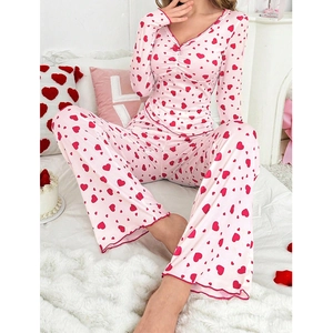 Detailansicht des rosa Pyjamas mit roten Herzprints und Wellensaum an den Bündchen