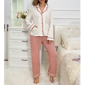 Women's two-piece pajama set featuring cream long-sleeve top and pink trousers with pleats