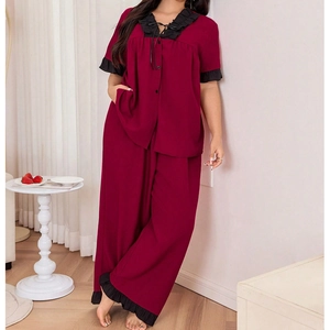 Detail of burgundy pajama set with black ruffle trim and elegant tie neckline