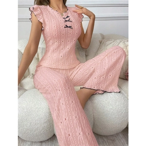 Detail of pink pointelle lounge set showing black bow accents and delicate knit texture