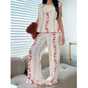 Women's floral pajama set with red rose print, lace collar, and ruffled hem in white