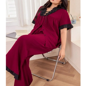 Detail of dark burgundy pajama set with black ruffle trim and elegant v-neck ribbon tie