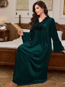 Detail of dark green velvet nightgown with elegant black lace embroidery and flared sleeves