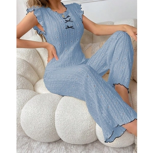 Detail of light blue two-piece pajama set with hollow out knit fabric and black bow tie