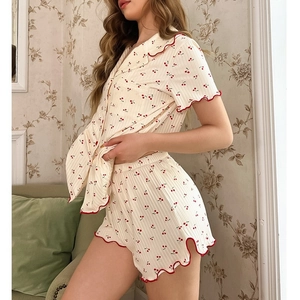 Short sleeve pajama set with red cherry print and wavy trim on cream ribbed fabric
