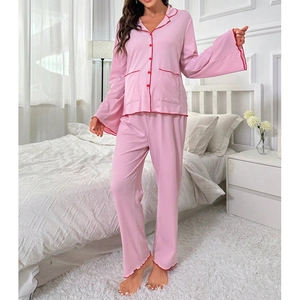 Detail of soft pink maternity pajama set with red wavy trim and button-down lapel collar