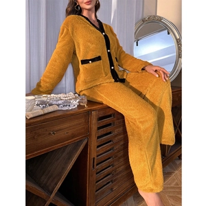 Détail d'un pyjama en polaire jaune moutarde avec boutons perlés et bordure noire chic