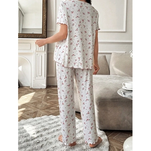Women's floral pajama set with short-sleeve top and loose pants in a cozy indoor setting