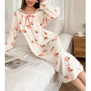Détail du col carré avec nœud en satin rose sur chemise de nuit imprimé pêche