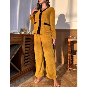 Détail d'un pyjama épais en polaire corail avec liserés noirs et boutons en perles pour femme