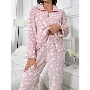 Detail of pink plush heart print pajamas with soft fleece texture and Love lettering