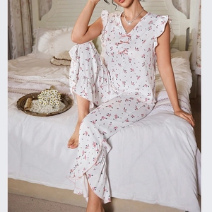 Close-up of V-neck lace edges and floral print detail on cream summer pajama set