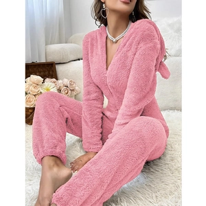 Detalle de mameluco rosa de felpa con capucha y textura de forro polar suave