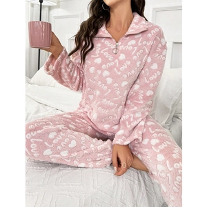 Detail of pink heart print fleece pajamas featuring a zip-up collar and soft texture