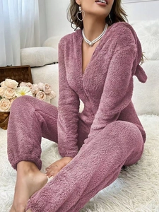 Détail d'un pyjama une-pièce en peluche violette avec capuche à oreilles et zip