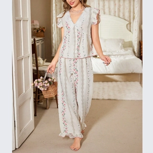 Vintage floral women's pajama set with V-neck top and trousers in a cozy bedroom setting