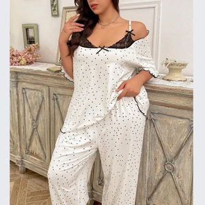 Detail of white pajama set with black polka dots, lace trim, and delicate bow