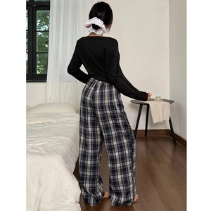 Pyjama femme avec haut noir à manches longues et pantalon large à carreaux classiques