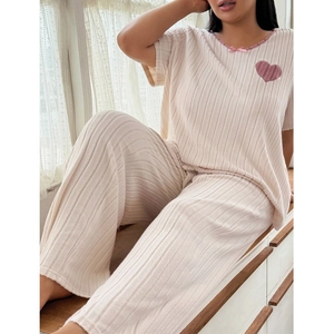 Detail of pink ribbed loungewear set with delicate lace neckline and heart patch embroidery
