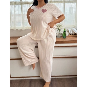 Women's pink ribbed pajamas set with heart embroidery and long pants in home setting