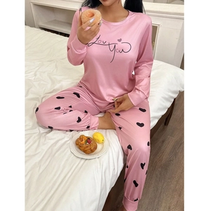 Détail d'un pyjama rose effet soie avec texte Love You et imprimés petits cœurs