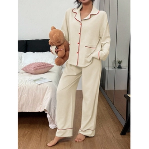 Pyjama femme beige avec liseré rouge contrasté, manches longues et col à revers boutonné
